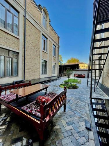 a patio with two benches in front of a building at Alpha Plaza Hotel & SPA in Tashkent