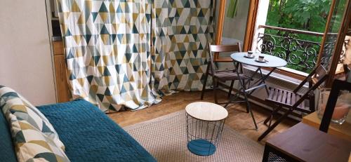 パリにあるStudio in Montmartreのソファ、テーブル、窓が備わる客室です。