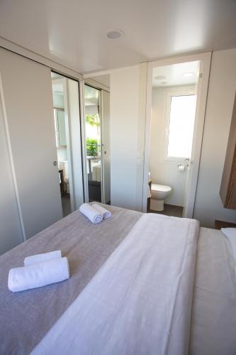 a bedroom with a large bed with two towels on it at Poseidon Mobile Home Resort in Makarska