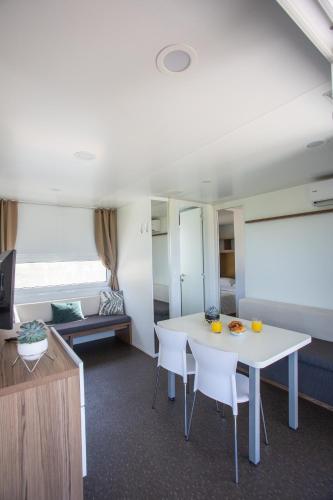 a living room with a white table and chairs at Poseidon Mobile Home Resort in Makarska