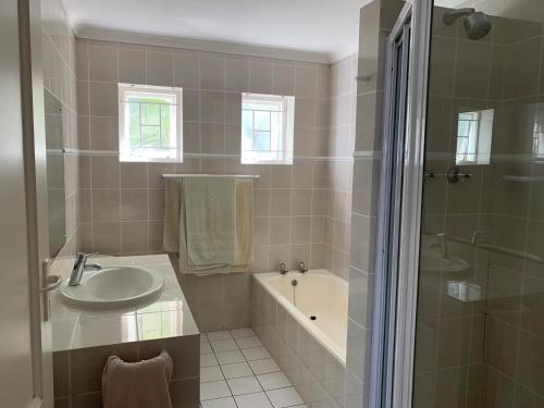 a bathroom with a sink and a tub and a shower at 56 Robberg Road Plettenberg Bay in Plettenberg Bay