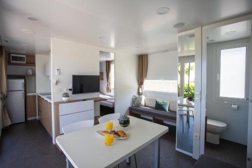 a living room with a white table in a room at Poseidon Mobile Home Resort in Makarska