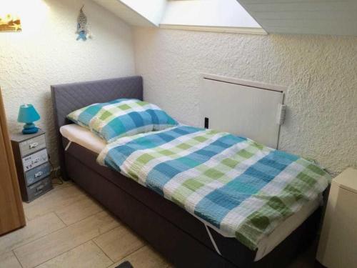 a small bedroom with a bed with a plaid blanket at Appartment 40 in Tossens in Butjadingen OT Tossens