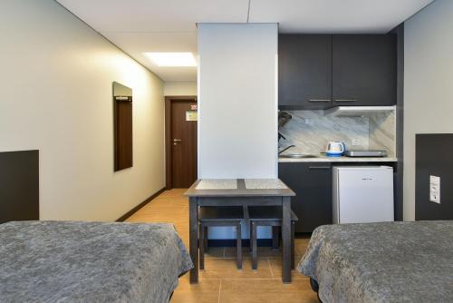 a small room with two beds and a kitchen at City Yard Inn Hotel in Tallinn