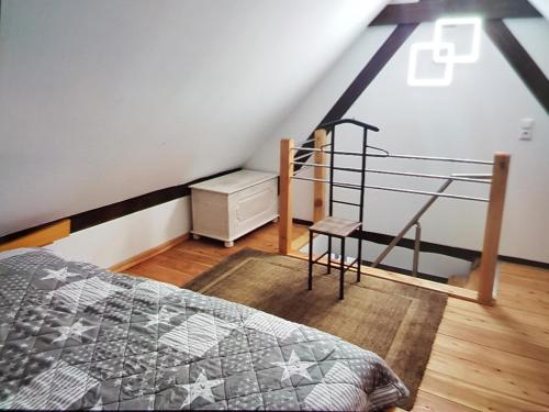 1 dormitorio con 1 cama y una escalera en el ático en Ferienwohnung Schmenkel, en Angermünde