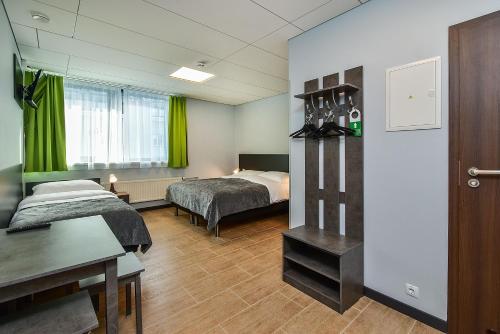um quarto de hotel com duas camas e uma secretária em City Yard Inn Hotel em Taline