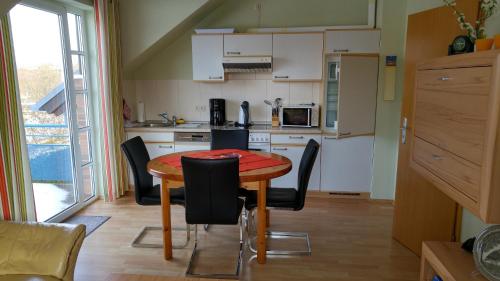 - une cuisine avec une table et des chaises dans la chambre dans l'établissement Fehmarn-OstseeferienZum Leuchtturm 150Whg 11, à Gollendorf