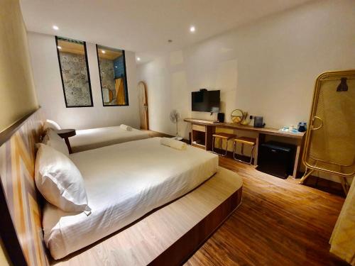 a hotel room with a large bed and a desk at MiM House in Hengchun