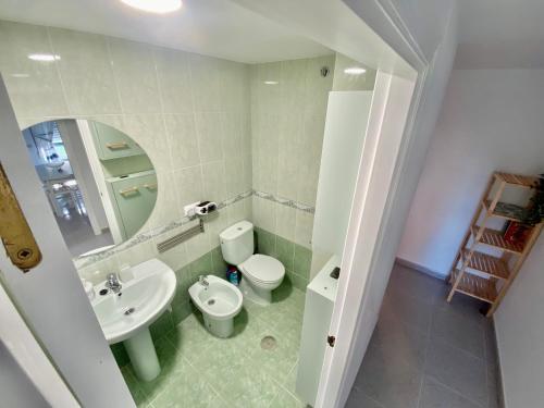 La salle de bains est pourvue de toilettes blanches et d'un lavabo. dans l'établissement Apartamento La Caridad, à La Caridad