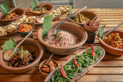 a wooden table topped with bowls of different types of food at Leopard Safaris Yala in Yala