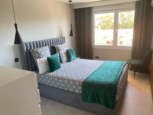 a bedroom with a bed with green and blue pillows at Ocean view, Luxury & Relax Dunas de Artola in Marbella