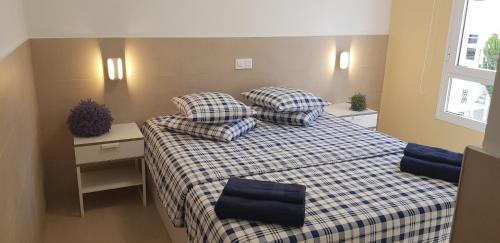 Un dormitorio con una cama con almohadas. en Stylish Apartment en Playa del Ingles