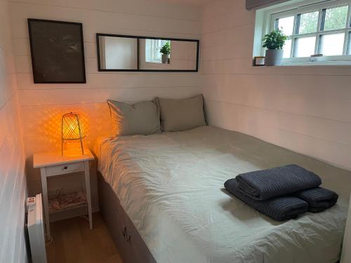 Un pequeño dormitorio con una cama con luz. en Mini Villa Stockholm Älvsjö S61, en Estocolmo