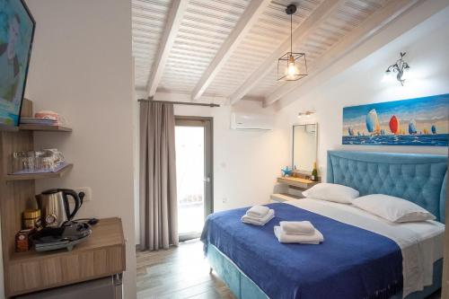 una camera da letto con un letto blu e asciugamani di Serenity Luxe Suites a Párga