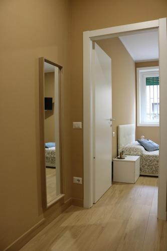 Habitación con espejo y dormitorio con cama. en Smart Flat Portello, en Milán