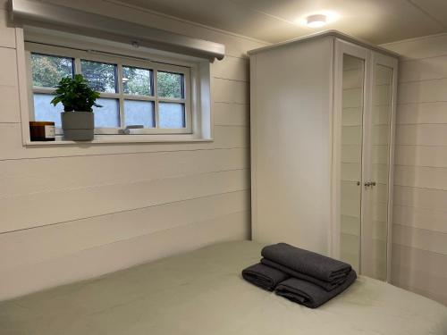 Habitación con una almohada en el suelo junto a una ventana en Mini Villa Stockholm Älvsjö S61, en Estocolmo
