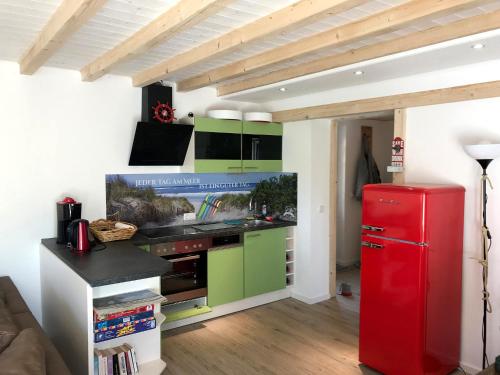 a kitchen with a red refrigerator and green cabinets at Vordeck FW 1 in Zingst