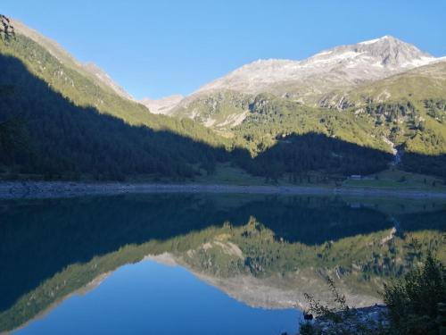 a view of a mountain reflecting in a lake at Appartement Sonneck in Lappago