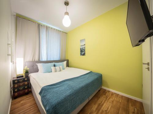 a bedroom with a bed and a yellow wall at Strandburg Azurblau in Burgtiefe auf Fehmarn 