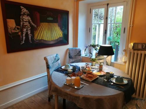een eetkamer met een tafel met eten erop bij La Halte chambres d'hôtes in Jeuxey