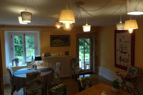 une salle à manger avec une table, des chaises et des lumières dans l'établissement La Halte, à Jeuxey