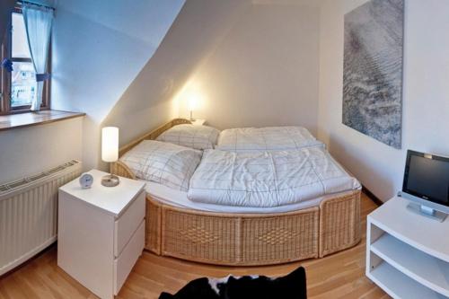 a small bedroom with a bed and a television at Altes Rektorenhaus 1 in Rieseby