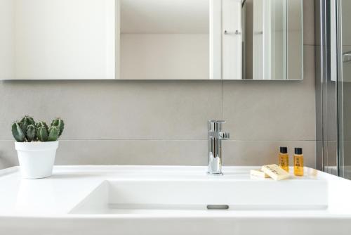 a white bathroom sink with a mirror above it at Aurà - Guest House Iblea in Ragusa