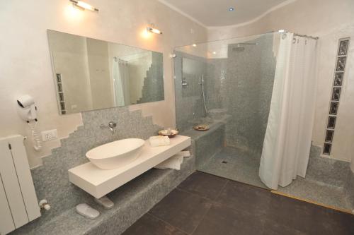 a bathroom with a sink and a shower at Hotel Astoria in Fermo