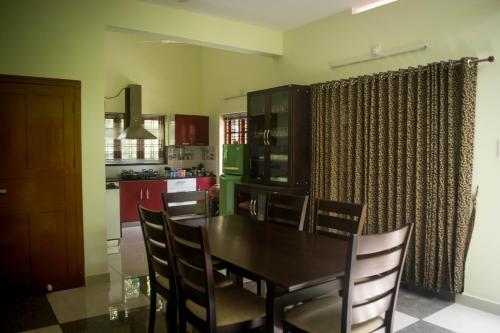 eine Küche mit einem Esstisch und Stühlen in der Unterkunft Maliyakal Homestay in Ernakulam
