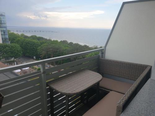 een balkon met een bank en uitzicht op de oceaan bij MM Luxus Meerblick Appartment 3 Personen in Międzyzdroje