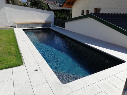 a swimming pool in the backyard of a house at Haus Grünbacher in Lienz