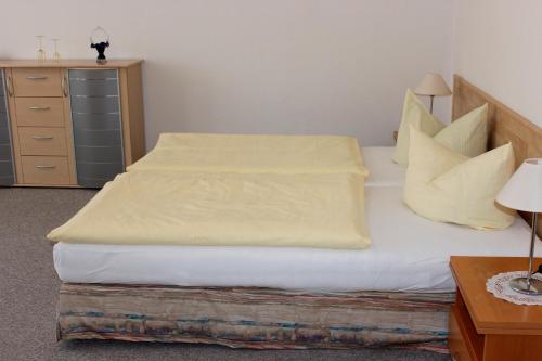ヴェルニゲローデにあるFerienwohnung 2 - 26714のベッドルーム1室(黄色いシーツとドレッサー付きのベッド2台付)