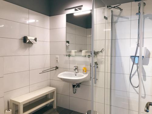 un baño con lavabo y ducha en Die Schlafstube, en Neuharlingersiel
