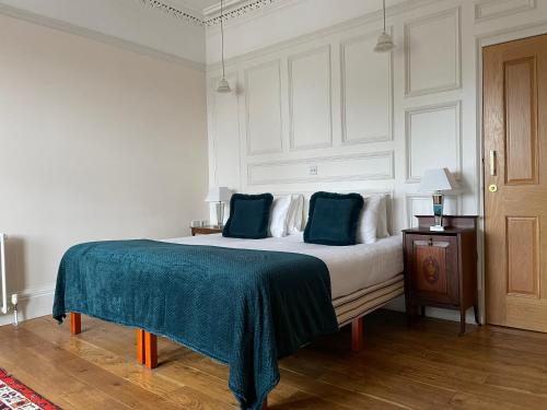 a bedroom with a bed with a blue blanket on it at The Fig Tree Hotel Markinch in Markinch