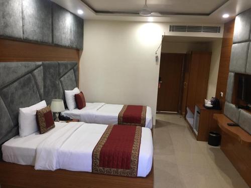 a hotel room with two beds and a television at HOTEL ANAND INTERNATIONAL in Bodh Gaya