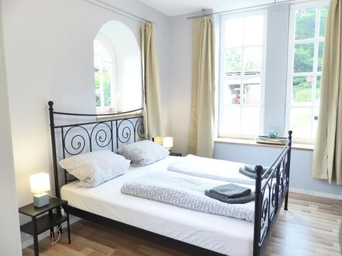 um quarto com uma cama em preto e branco e 2 janelas em Ferienwohnung Sonnenstrahl em Walsrode