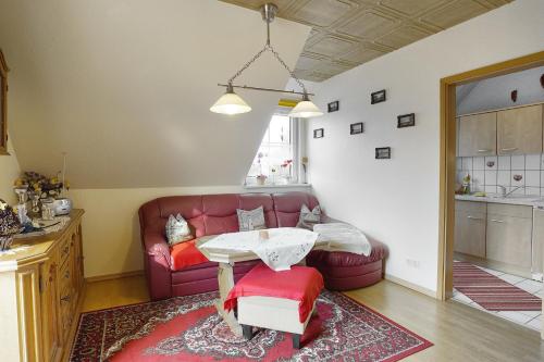 uma sala de estar com um sofá vermelho e uma mesa em Schäfer, Renate FW 1 em Zingst