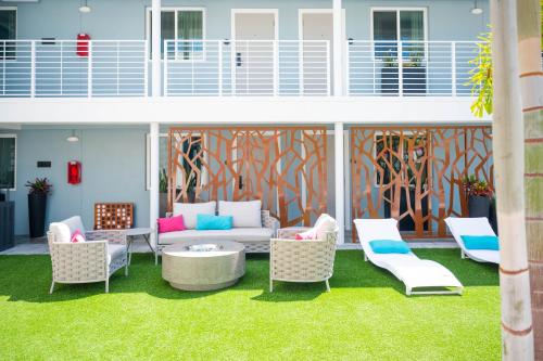 a patio with a couch and chairs on the grass at The Saint Hotel in St Pete Beach