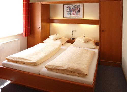 Duas camas num quarto com um espelho em Ferienwohnung Viaduktblick mit Balkon & MeineCardPLUS em Willingen