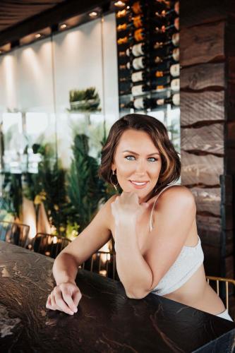 a woman sitting at a table in a bar at The Saint Hotel in St Pete Beach