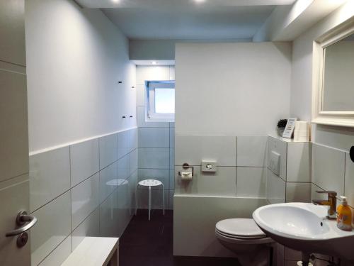 bagno bianco con servizi igienici e lavandino di Die Schlafstube a Neuharlingersiel