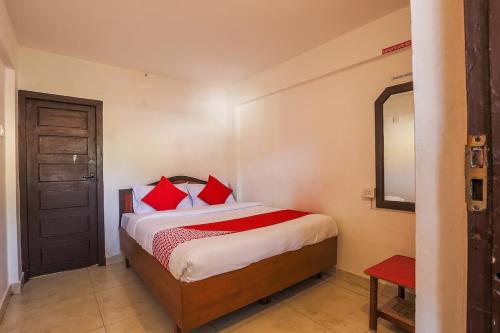 a bedroom with a bed with red pillows at SK Residency in Ooty