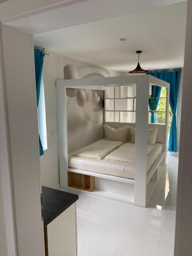 a small white bed in a room with blue curtains at Designpension Idyll Nr21 Hotel Garni in Wernigerode