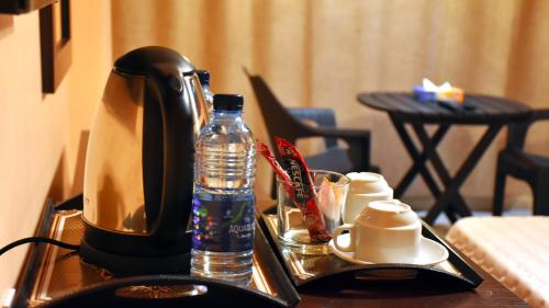 una cafetera y una botella de agua en una mesa en Al-Naher Al-Khaled Hotel, en Áqaba