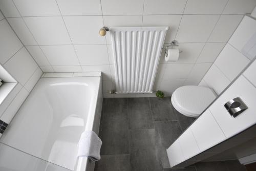 een witte badkamer met een toilet en een bad bij Am Schloss 19 in Schwerin
