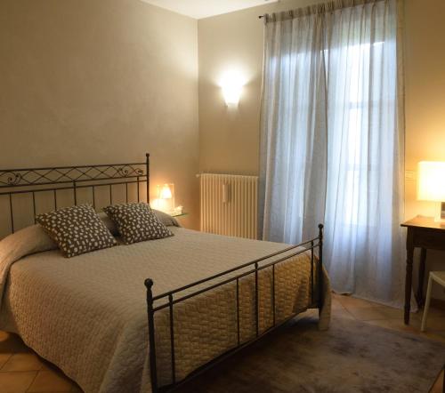 1 dormitorio con 1 cama y una ventana con cortinas en Profumi..., en Vinchio