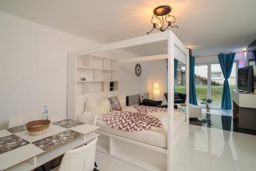 a white bedroom with a bed and a desk at Designpension Idyll Nr21 Hotel Garni in Wernigerode