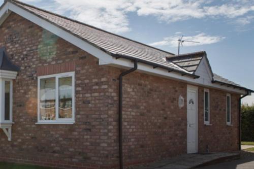 a brick house with a pitched roof at Cozy Dog Friendly cottage near Bridlington in Bridlington