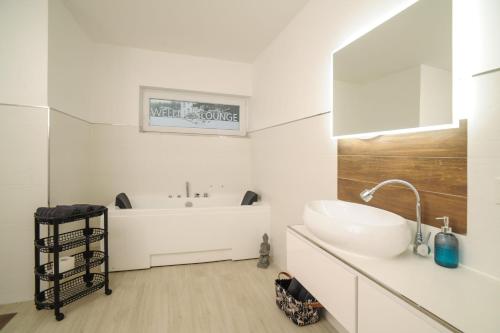 a white bathroom with a sink and a mirror at Designpension Idyll Nr 3 - Hotel Garni - Sennhütte 1 in Wernigerode
