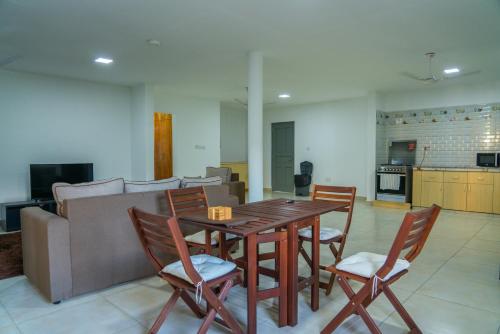 sala de estar con mesa de madera y sillas en E&E Self Catering en Beau Vallon